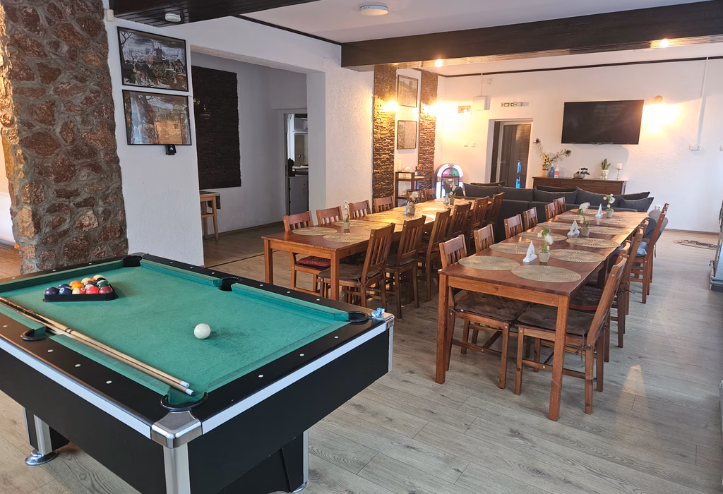 Sala mare a Casei Mari, mese lungi din lemn și arcuri de piatră
