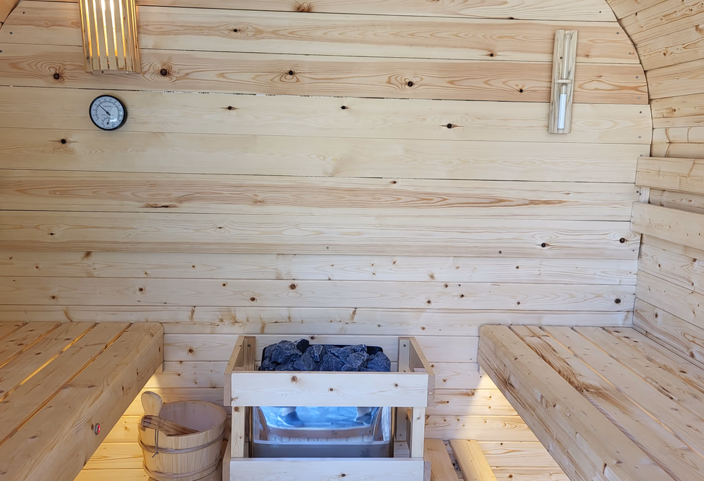 Interior saunei finlandeze cu bănci din lemn și sobă cu pietre